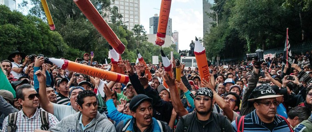 Hundreds of men march for labor rights in Mexico City, Mexico. Some carry inflatable giant pencils as part of the protest. 