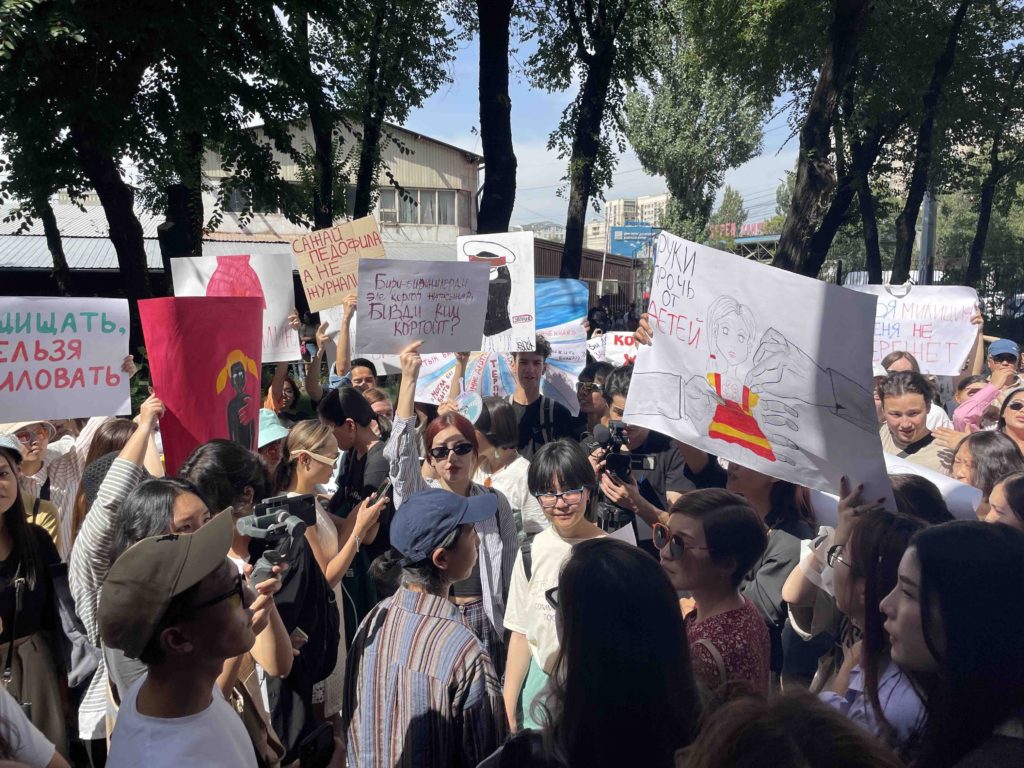 Holding handwritten signs over their heads, a group of women in Kyrgyzstan protest against femicide and lack of government action to stop violence against women.