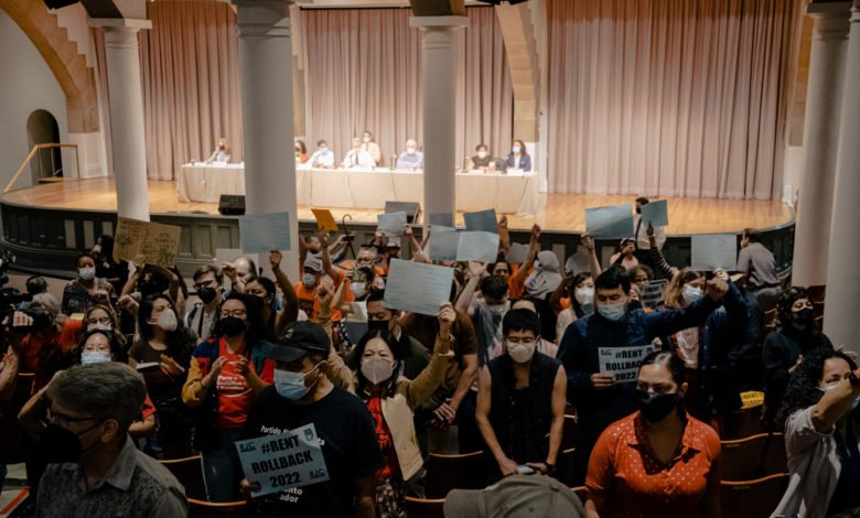 Holding signs in the air, a group of New York City tenants disrupt an officials' vote to increase rent on rent-stabilized apartments.