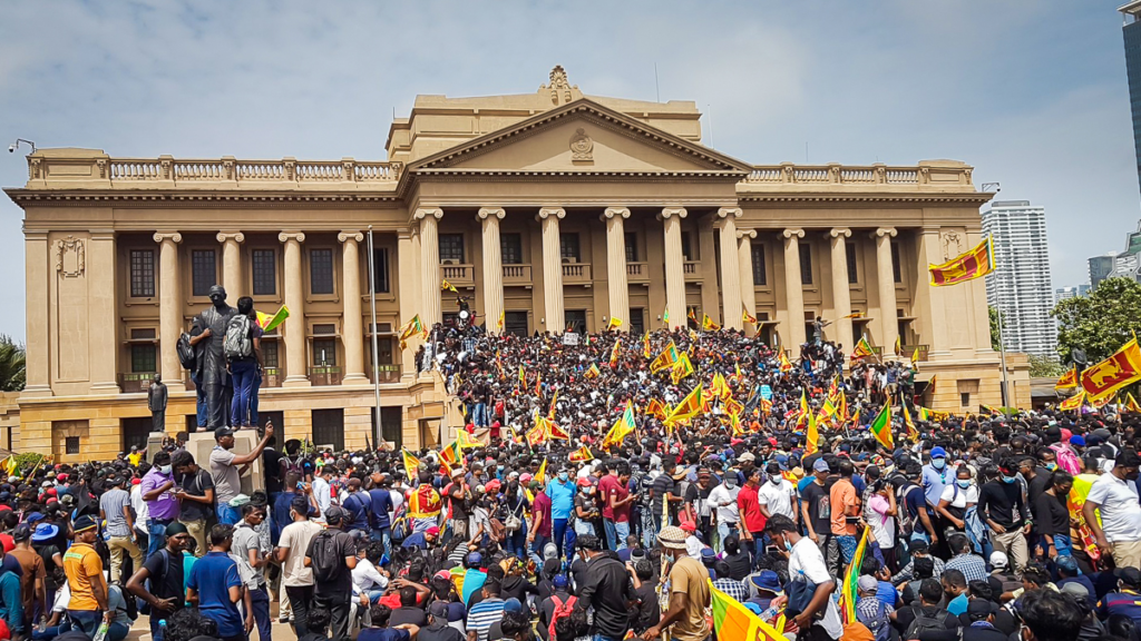 A large crowd of Sri Lankan protesters rally in front of the president's residence, carrying the national flag and demanding the president's resignation.