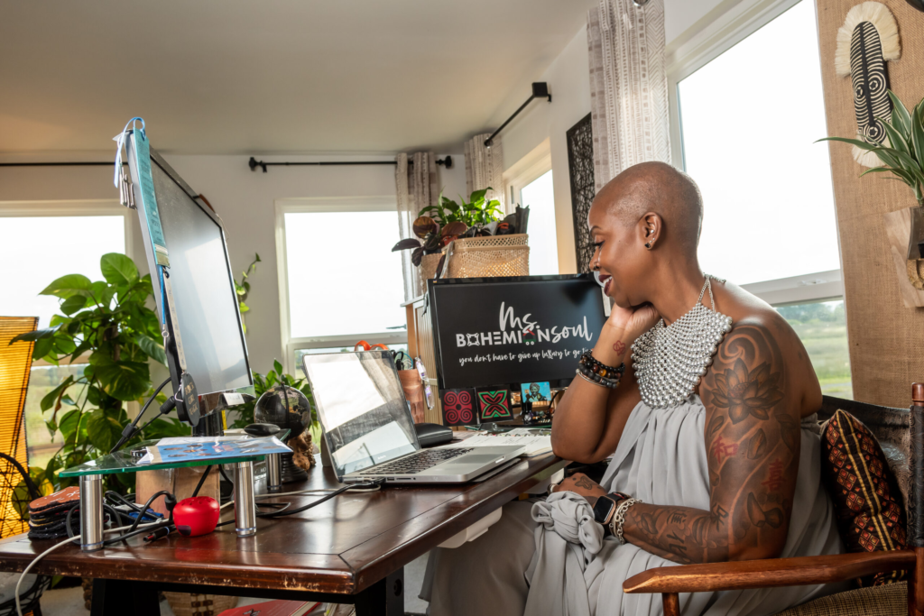 African-American Jewel Pearson sits at her computer in her tiny home where she helps make this style of housing more inclusive.