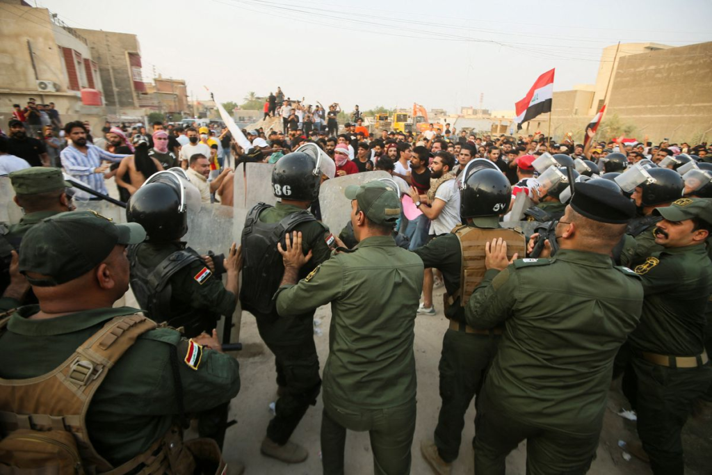 Police clash with demonstrators gathered in front of the Turkish consulate as they protest against a Turkish attack on a mountain resort in Iraq's northern province of Dohuk, in Basra , Iraq.