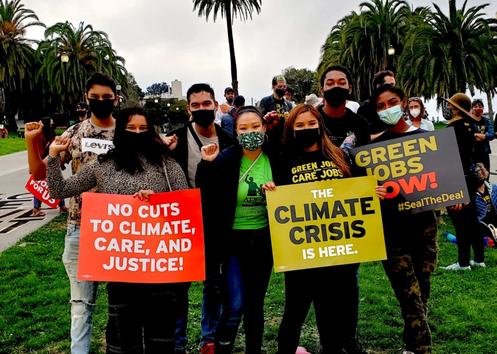 A diverse group of young people in California hold signs for climate action.
