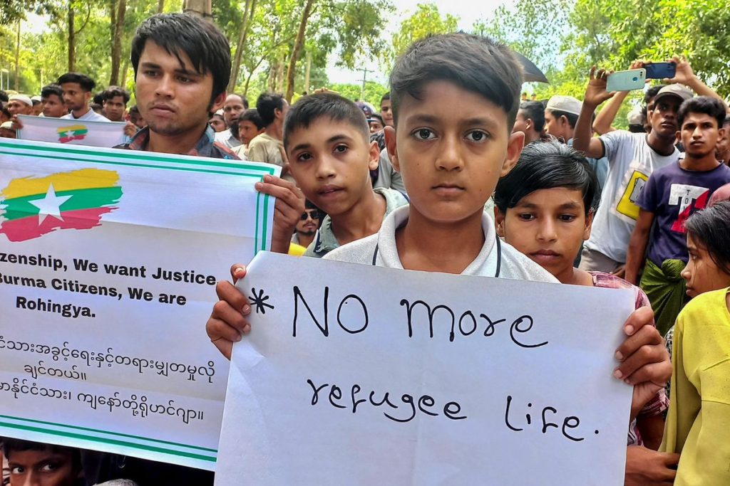 Rohingya youth hold signs during protests at refugee camps in Bangladesh. 