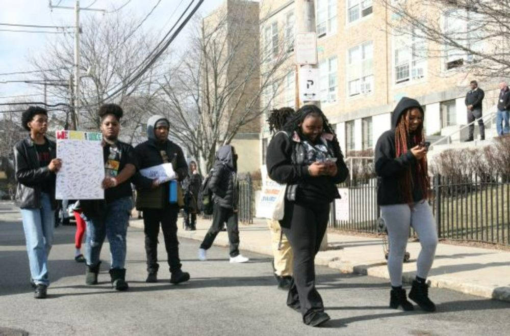 Black students march down the street during an anti-racism protest walkout from school.