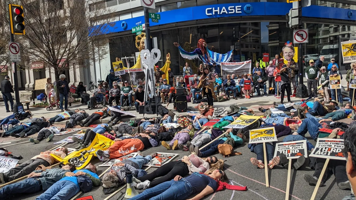 Close to a hundred senior citizens hold signs outside Chase Bank and perform a die-in, calling for fossil fuel divestment.