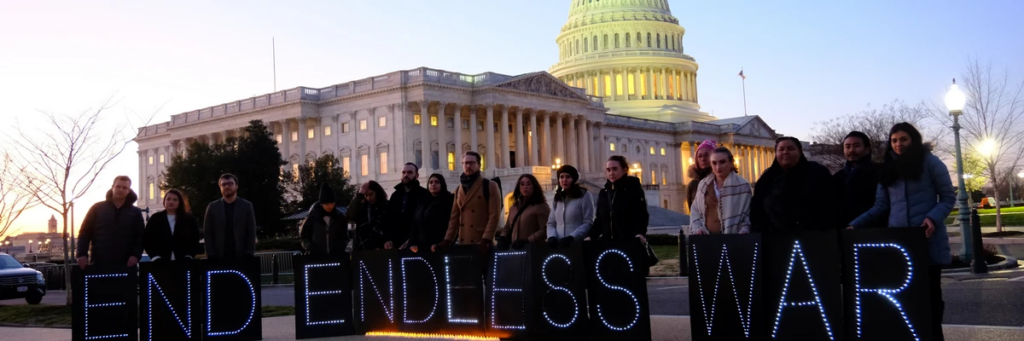 A dozen peace activists hold illuminated signs that spell out "End Endless Wars" as they demonstrate in front of the US Capitol Building.